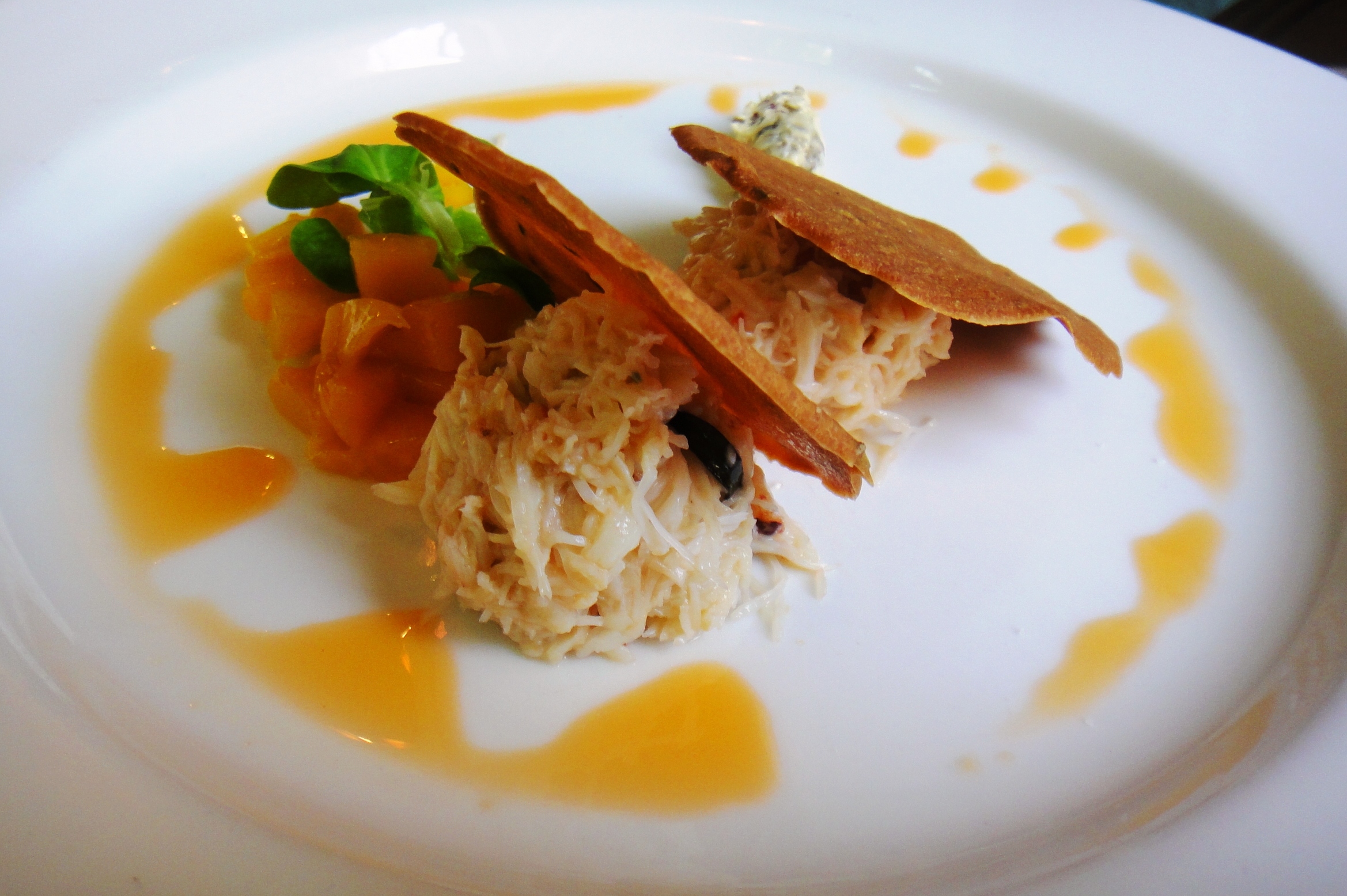 Peekytoe crabmeat with cumin crackers and mango salsa, surrounded by lobster oil